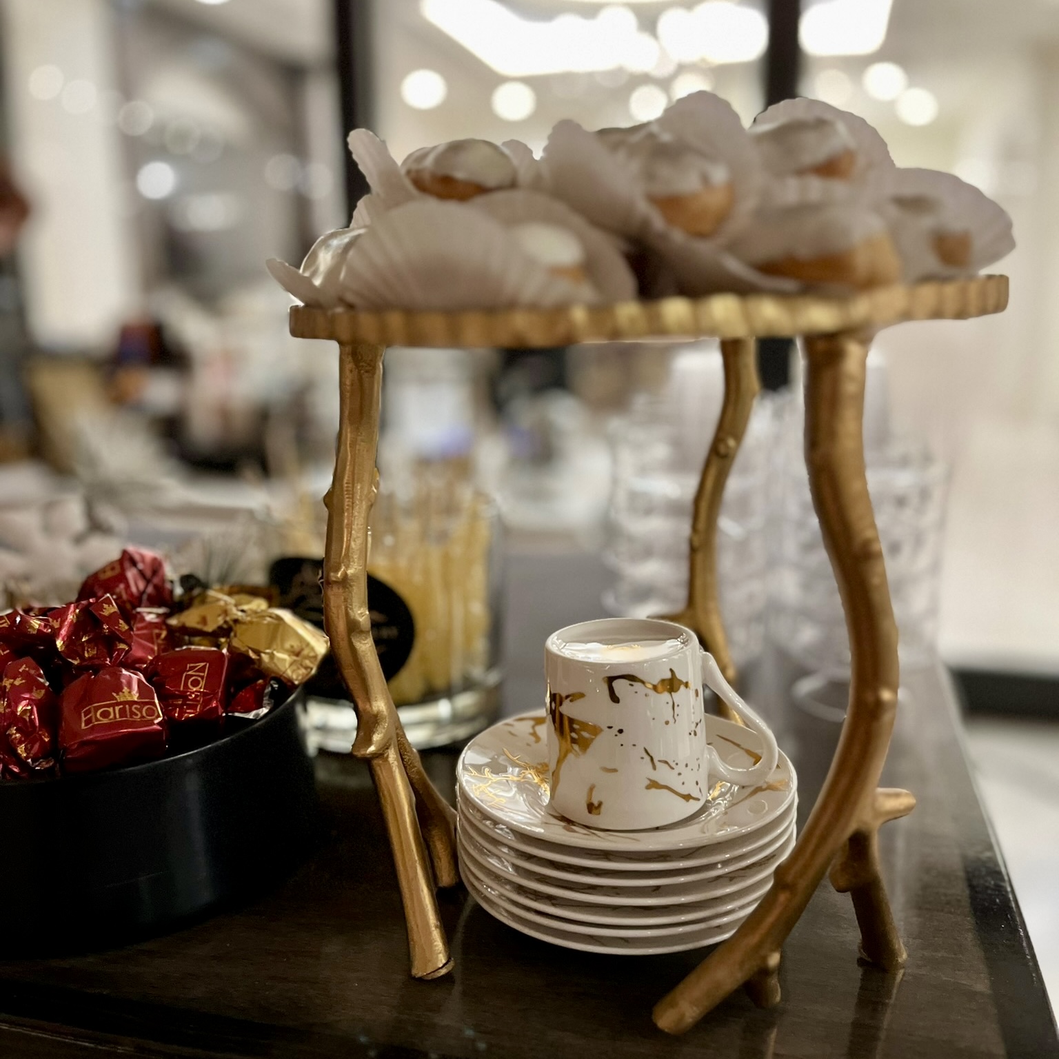 Gold tiered stand with pastries and teacups
